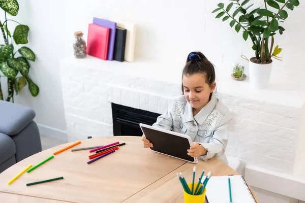 Niña utilizando el chat de vídeo en la tableta en casa. Espacio para texto — Foto de Stock