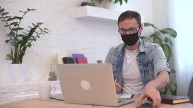 Coronavirus ve Coronacrisis. Dizüstü bilgisayardaki stresli adam tapınaklara masaj yapıyor. Evde iş sorunları yaşıyor..