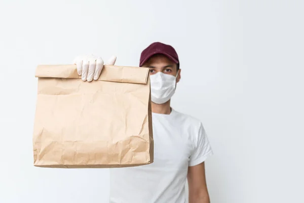 Correio, entregador em luvas de látex médico e máscara entrega com segurança compras on-line em caixa branca para a porta durante a epidemia de coronavírus, COVID-19. Fique em casa, conceito seguro. — Fotografia de Stock