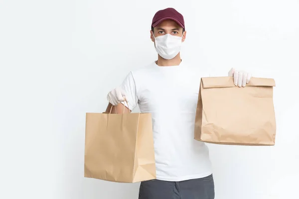 Kurir, leverans man i medicinska latexhandskar och mask säkert levererar online inköp i vit låda till dörren under coronavirus epidemin, COVID-19. Stanna hemma, tryggt koncept. — Stockfoto