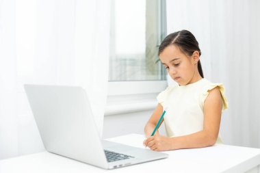 Neşeli küçük kız çocukları dizüstü bilgisayar kullanıyor, online e-öğrenim sistemi üzerinden çalışıyorlar.