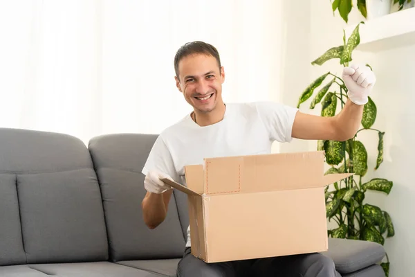 Concept de poste, de maison et de style de vie - homme souriant avec des boîtes en carton à la maison — Photo