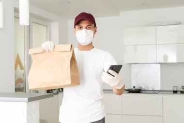 Karton kutuları tıbbi lastik eldiven ve maskeyle taşıyan teslimatçı. kopyalama alanı. Hızlı ve ücretsiz teslimat. İnternetten alışveriş ve ekspres teslimat. Karantina