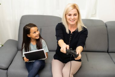 iyi bir ilişki içinde küçük tatlı bir kız ve genç bir anne oyun oynuyor birlikte oturma odasında oturmuş aile tatilinin tadını çıkarıyorlar..