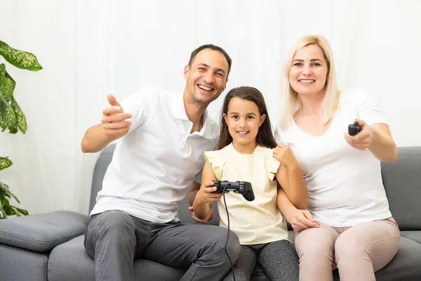 Familia feliz jugando videojuegos en casa y divirtiéndose juntos. — Foto de Stock