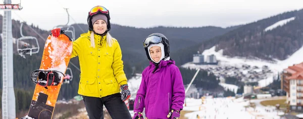 Familie van snowboarders in wintersportplaats in de bergen — Stockfoto