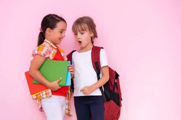 Two young girls whispering and sharing a secret during class in school — Stock Photo, Image