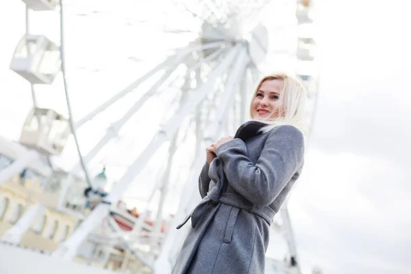 La jeune fille se promène dans la ville à proximité des sites touristiques. Grande roue. Parc d'attractions. automne — Photo