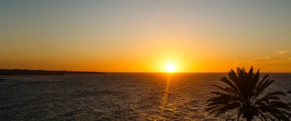 Una puesta de sol sobre un cuerpo de agua — Foto de Stock