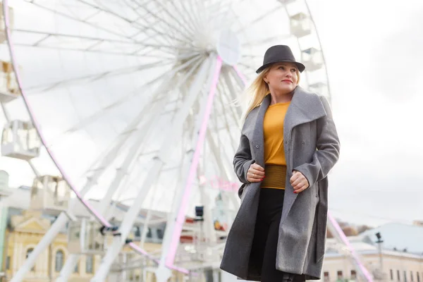 La jeune fille se promène dans la ville à proximité des sites touristiques. Grande roue. Parc d'attractions. automne — Photo