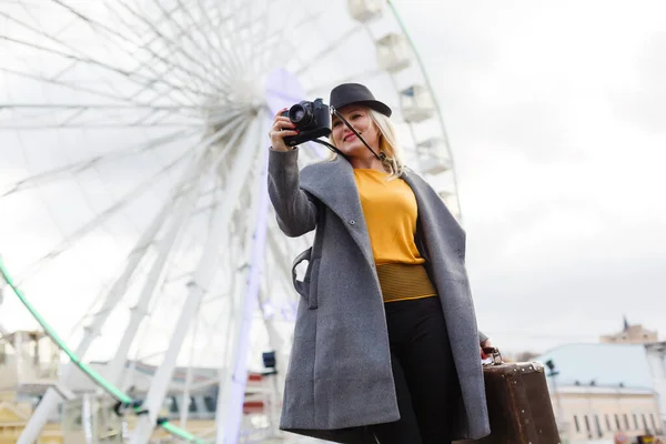 Das junge Mädchen läuft in der Nähe von Sehenswürdigkeiten durch die Stadt. Riesenrad. Freizeitpark. Herbst — Stockfoto