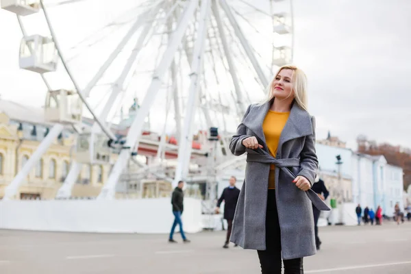 Das junge Mädchen läuft in der Nähe von Sehenswürdigkeiten durch die Stadt. Riesenrad. Freizeitpark. Herbst — Stockfoto