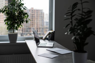 Rahat bir iş yeri. Üzerinde tahta masa ve dizüstü bilgisayar olan rahat bir iş yeri.