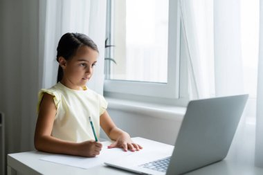 ev, eğlence, teknoloji ve internet konsepti - evde dizüstü bilgisayarı olan küçük kız, küçük kız görüntülü sohbet kullanıyor