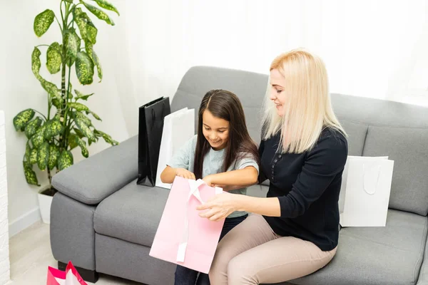 Happy Mother and daughter unpacking shopping bags in the living-room — Stock Photo, Image