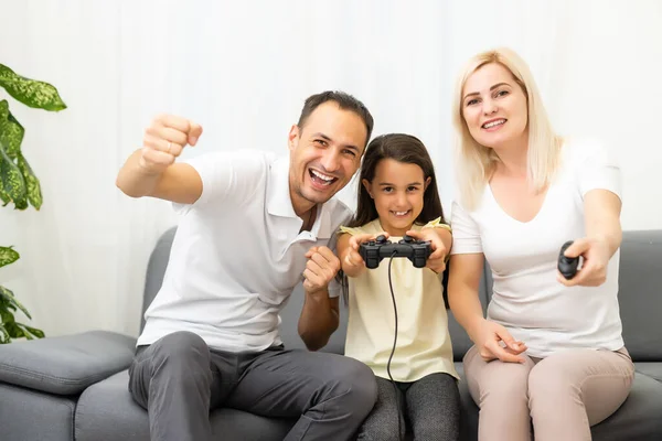 Счастливая семья играет дома в видеоигры и веселится вместе. — стоковое фото