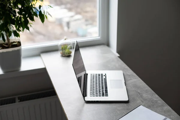 Local de trabalho cinza com laptop e grande janela — Fotografia de Stock