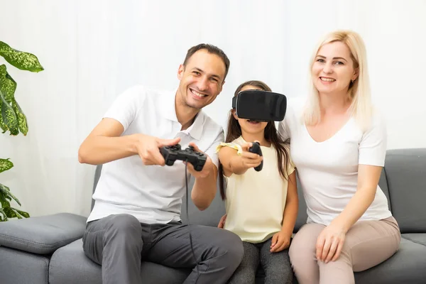 Famiglia felice seduta su un divano e giocare ai videogiochi. — Foto Stock