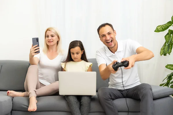 Glückliche Familie, die zu Hause Videospiele spielt und zusammen Spaß hat. — Stockfoto