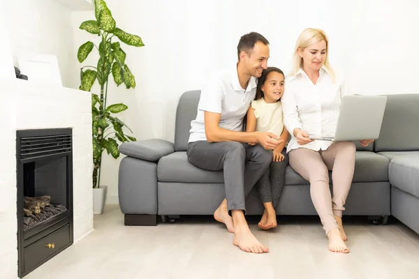 Rodzinne zakupy online. Szczęśliwa rodzina uśmiechnięta siedząc na kanapie i robiąc razem zakupy online — Zdjęcie stockowe