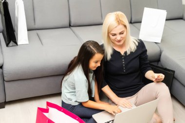 Bilgisayarlı mutlu anne ve çocuğun fotoğrafı, online alışveriş.