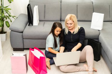 Bilgisayarlı mutlu anne ve çocuğun fotoğrafı, online alışveriş.