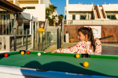 Deniz kenarında bilardo masası, aile bilardo oynar.