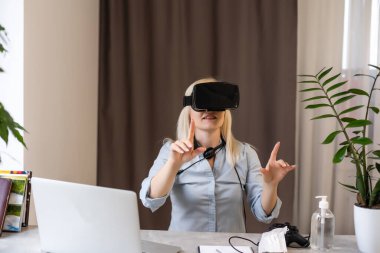 Bilgisayar oyunu denetleyicisi ile oynayan kadının dijital bileşimi ve parlak bulanık arkaplan ile sanal gerçeklik kulaklığı