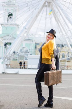 Genç kız şehrin etrafında yakın görüşte dolaşır. Dönme dolap. Eğlence parkı. sonbahar