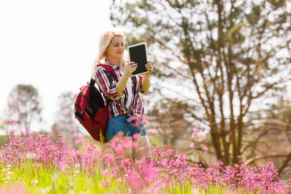 Mulher bonita usando tablet computador no fundo montanhas ao ar livre. — Fotografia de Stock