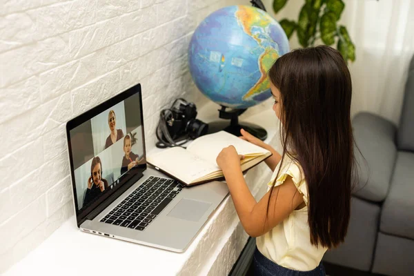 Menina minúscula olhando para a tela do laptop com expressão de surpresa e emoção. Uma menina esperta e sorridente a tirar apontamentos. Comunicação no conceito de negócio. — Fotografia de Stock