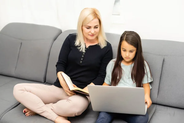 Famiglia guardando il computer portatile d'argento insieme, madre e figlia online — Foto Stock
