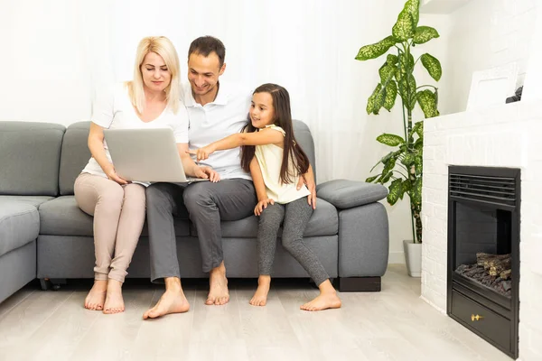 Familjeshoppning online. Glad familj ler medan du sitter på soffan och handlar online tillsammans — Stockfoto