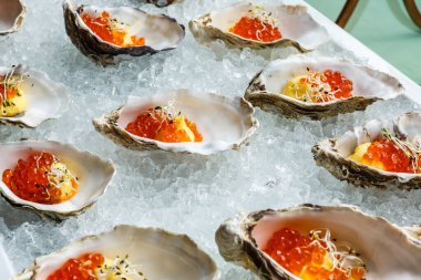 Mavi tabakta taze istiridye, istiridye, limon ve buzla servis edilir. Sağlıklı deniz ürünleri. Restoranda şampanyayla istiridye yemeği. Gurme yemekleri..