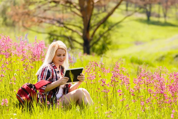 Belle jeune femme utilisant tablette informatique sur fond de montagnes à l'extérieur. — Photo