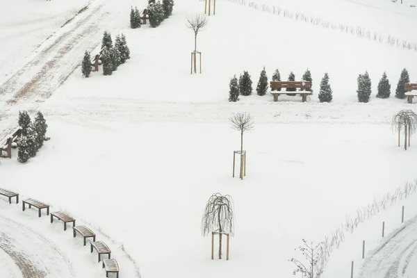 Трактор-екскаватор видаляє сніг на міському подвір'ї. робота комунальних послуг — стокове фото