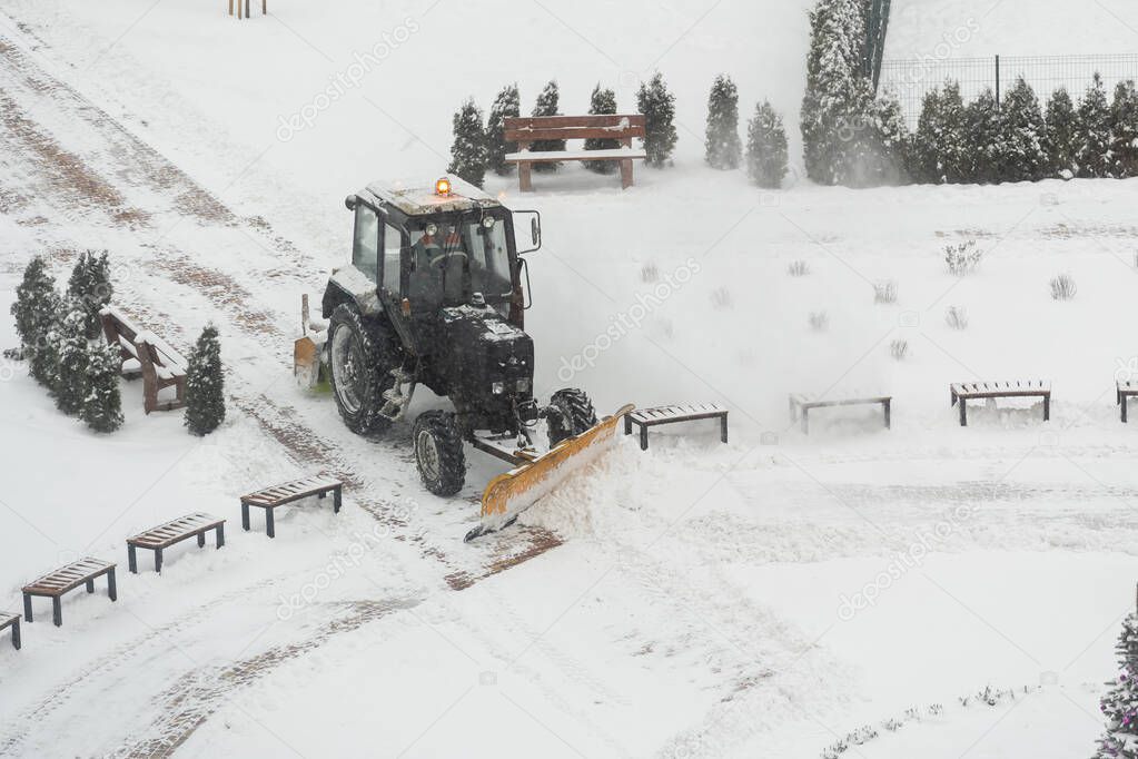 Tractor vehicle cleaning the yard from the snow storm