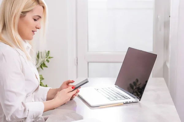 Rear view of business woman hands busy using laptop at office desk, with copyspace