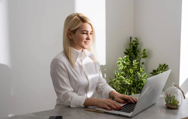 Happy Young Beautiful Woman met behulp van laptop, Binnen op witte muur achtergrond — Stockfoto