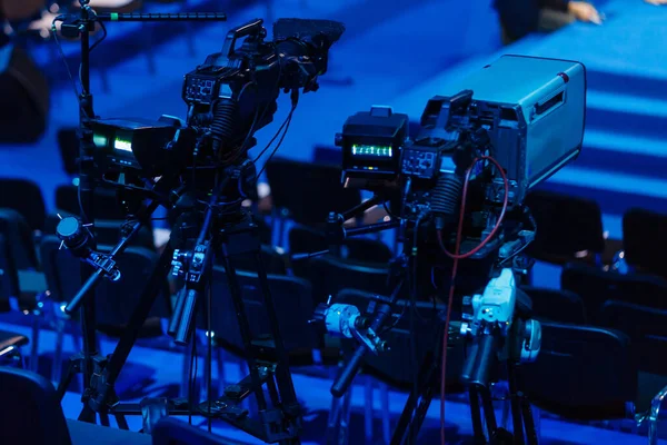 Videocámara profesional, videocámara en trípode, silueta negra sobre fondo azul — Foto de Stock