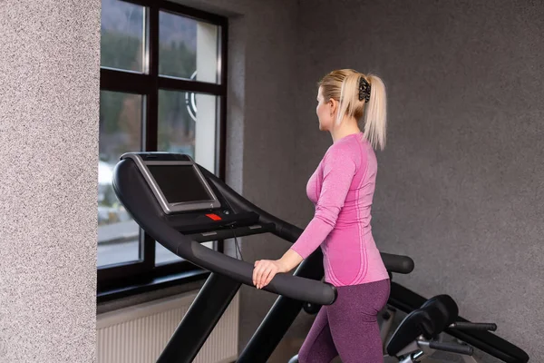 The young girl on a racetrack, woman on treadmill — Stock Photo, Image