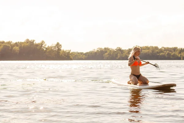 Mujer atractiva joven en stand up paddle board en el lago, SUP — Foto de Stock