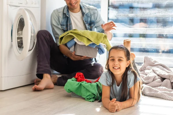 Familia feliz cargando ropa en la lavadora en casa — Foto de Stock