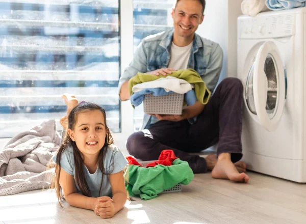 Feliz familia hombre padre cabeza de familia e hija niño en la lavandería con lavadora — Foto de Stock