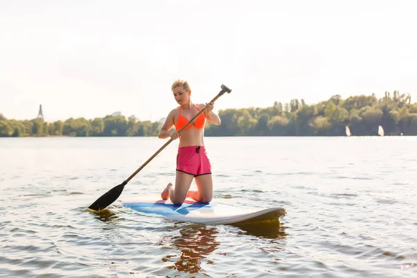 Молодая привлекательная женщина на подставной доске в озере, SUP — стоковое фото