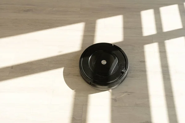 Роботизований пилосос на ламінованій дерев'яній підлозі у вітальні — стокове фото