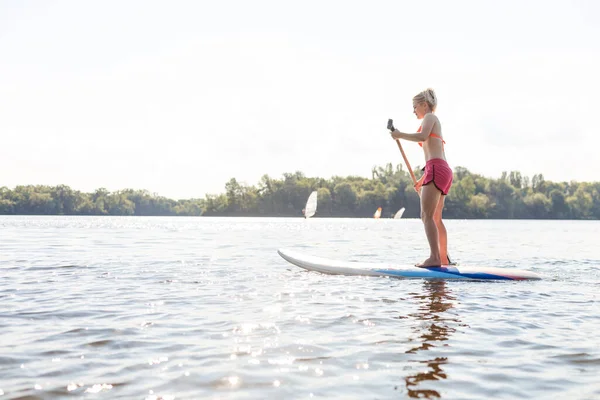 Young attractive woman on stand up paddle board in the lake, SUP — Stock Photo, Image