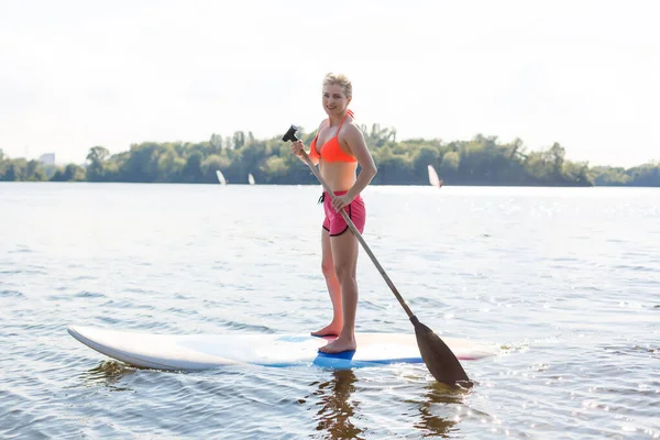 Mujer atractiva joven en stand up paddle board en el lago, SUP —  Fotos de Stock