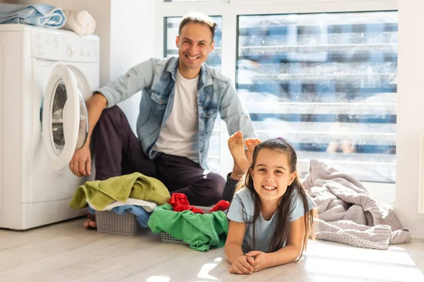 Familia feliz cargando ropa en la lavadora en casa — Foto de Stock