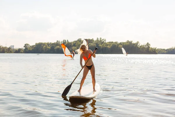Mujer atractiva joven en stand up paddle board en el lago, SUP —  Fotos de Stock